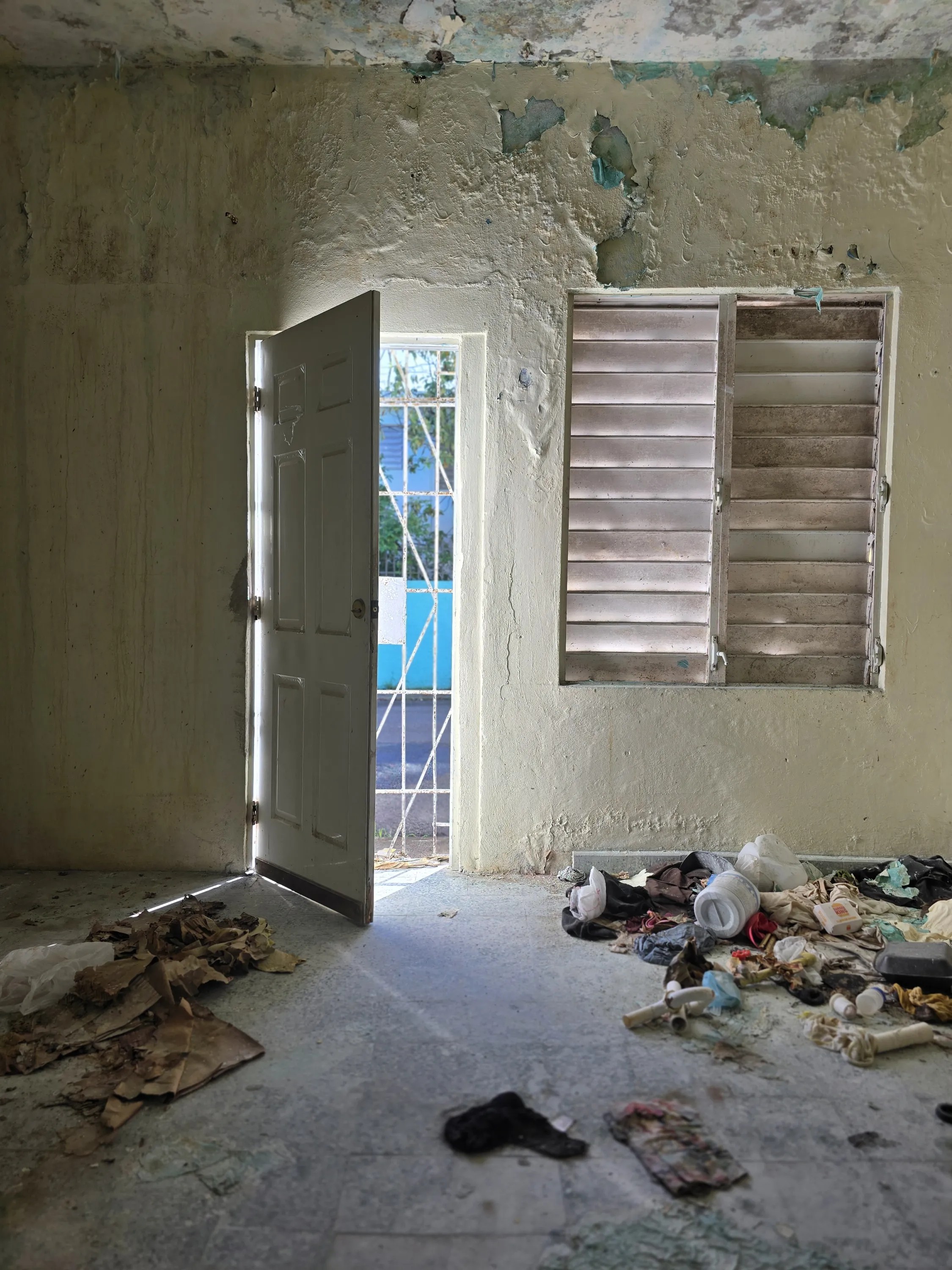 Interior propiedad abandonada Río Piedras Puerto Rico puerta abierta ventana deterioro urbano