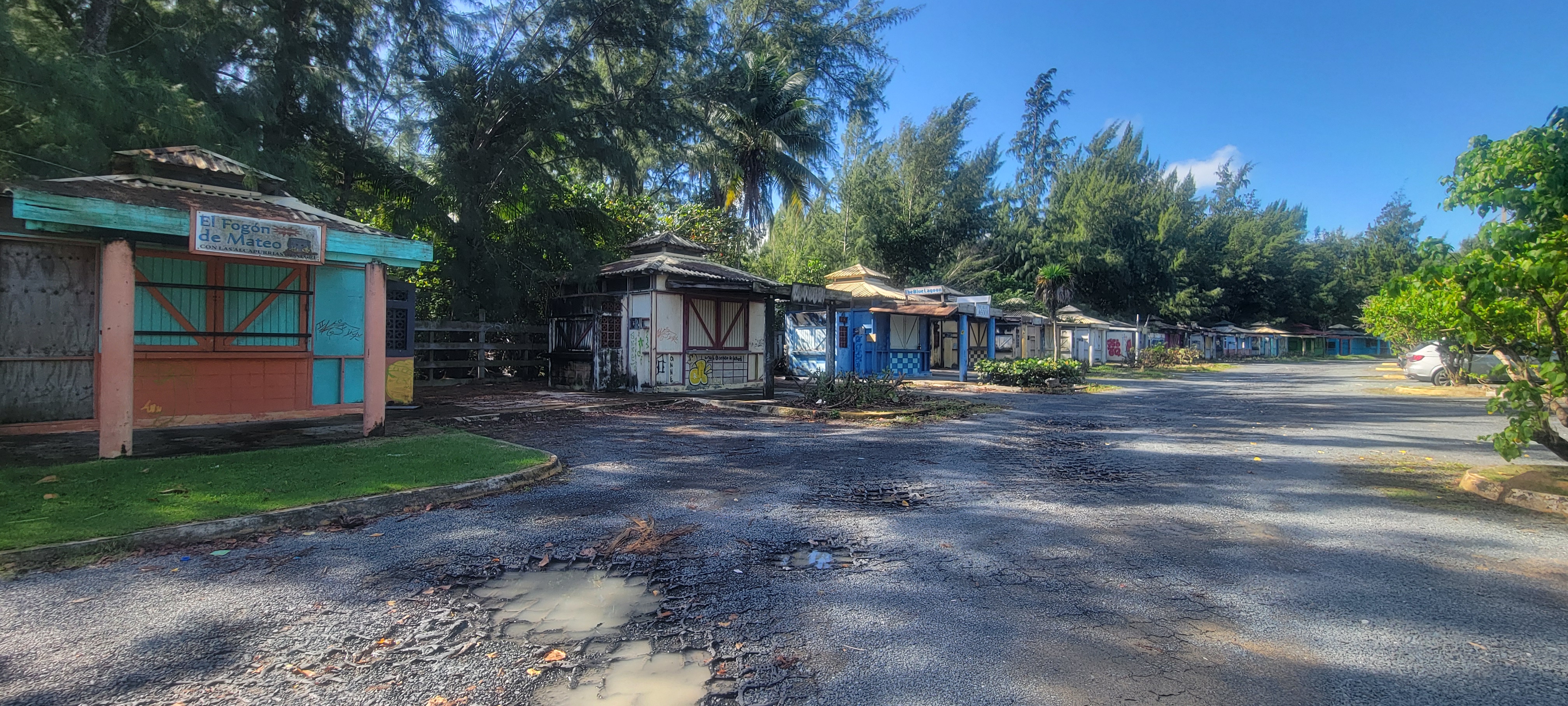 Corredor de quioscos vacíos en Loíza Puerto Rico con estructuras coloridas cerradas y deterioradas a lo largo de la carretera costera