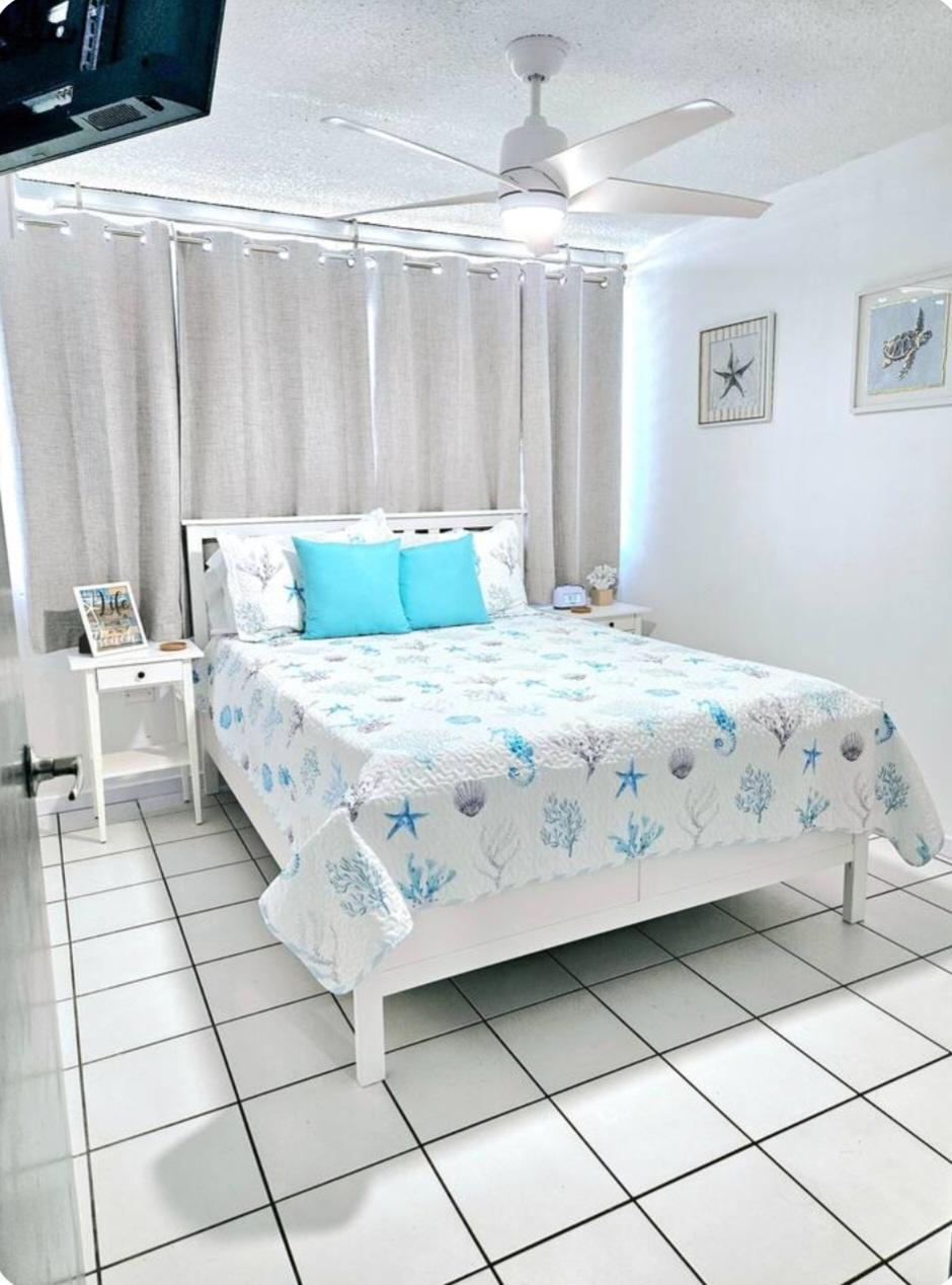 Habitación principal de apartamento en Luquillo Puerto Rico con cama doble decoración de playa y ventilador de techo