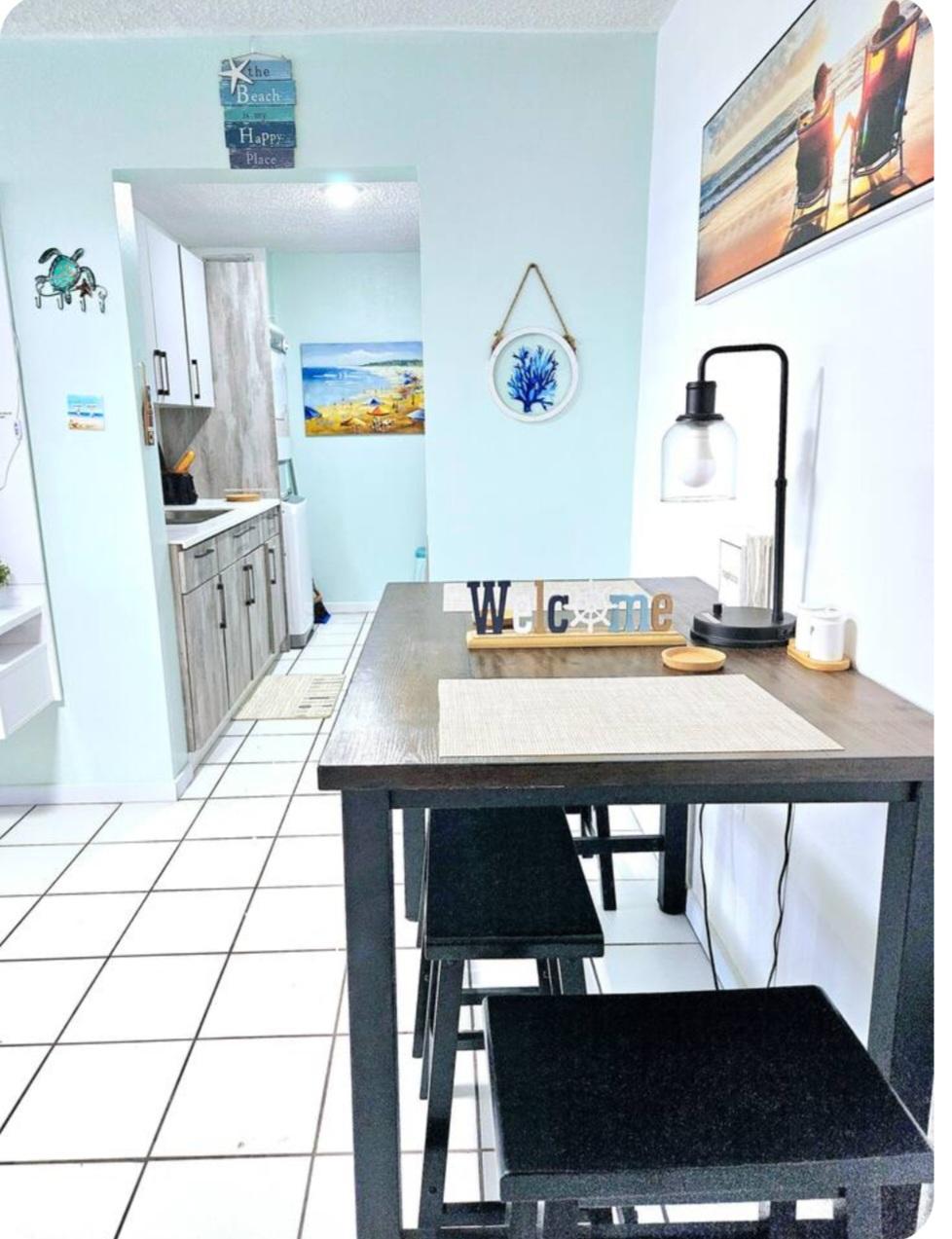 Área de comedor de apartamento en Luquillo Puerto Rico con decoración playera y acceso a la cocina