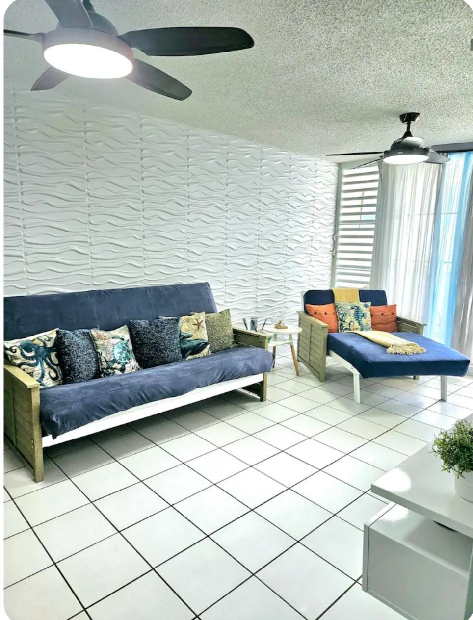 Sala amplia de apartamento amueblado en Luquillo Puerto Rico con pared de textura y ventiladores de techo